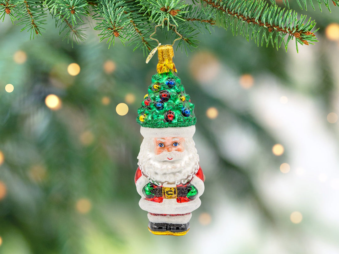 A classic red santa ornament wearing a Christmas tree instead of a hat.