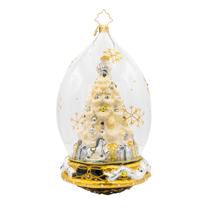 This glass dome ornament captures the essence of Christmas with a beautifully decorated tree, sparkling gifts, and a touch of festive magic. View of front.