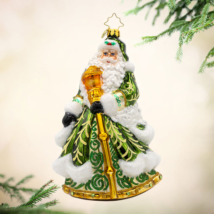 This European-style Santa Claus ornament dons a vibrant green robe, adorned with intricate details and shimmering embellishments. View of front.