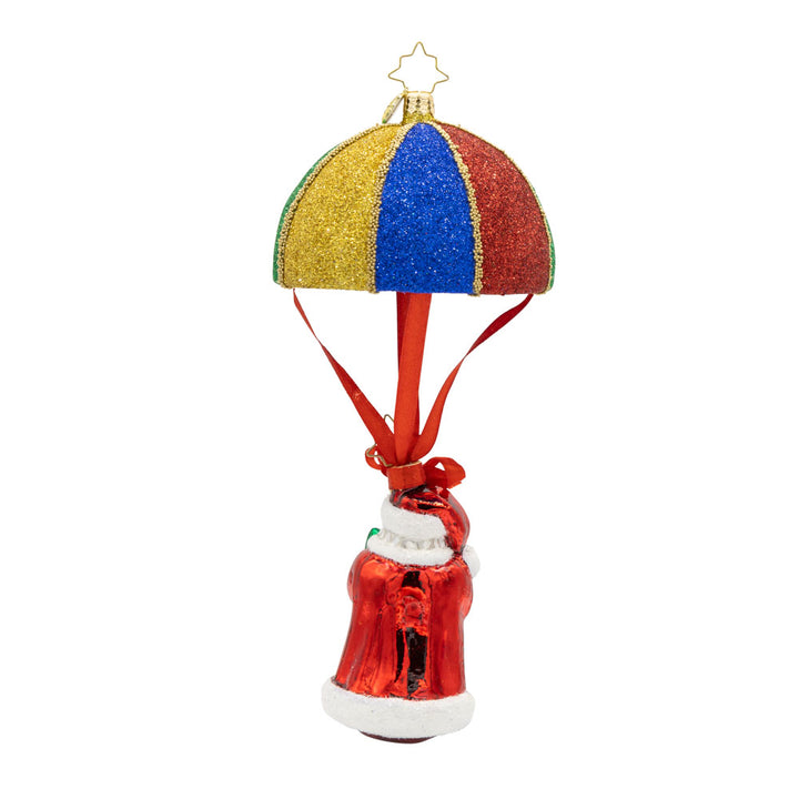 Tidings from Above Santa ornament. This ornament features Santa soaring through the air with a colorful parachute, his tiny Christmas tree in hand. View of back.