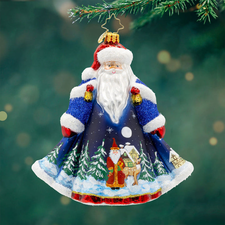 Santa of the Midnight Sky ornament. Santa dons a blue robe with a hand painted scene of him journeying through the night on Christmas Eve. View of front.