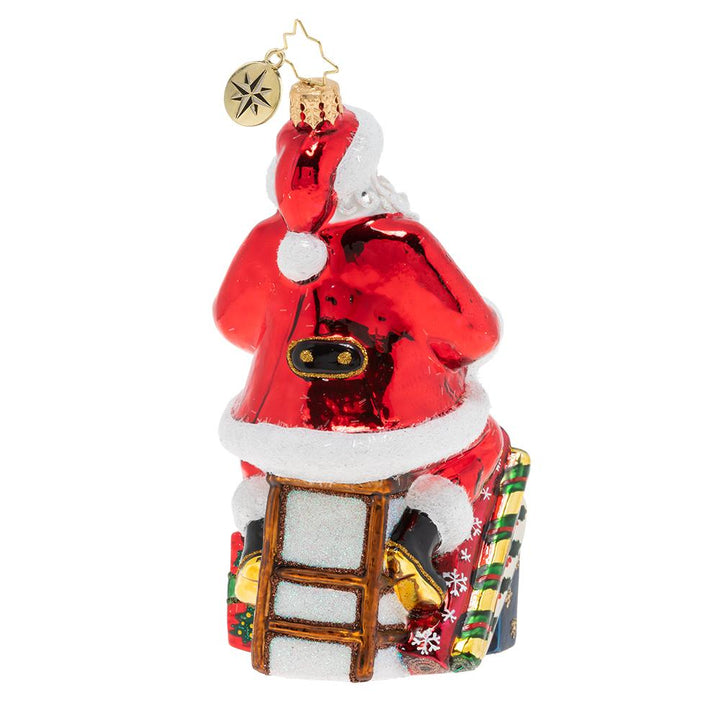 Back - Ornament Description - Workshop Wonders: Santa is wrapping gifts for the holiday! His nimble fingers and eye for detail make him a gift wrapping extraordinaire!